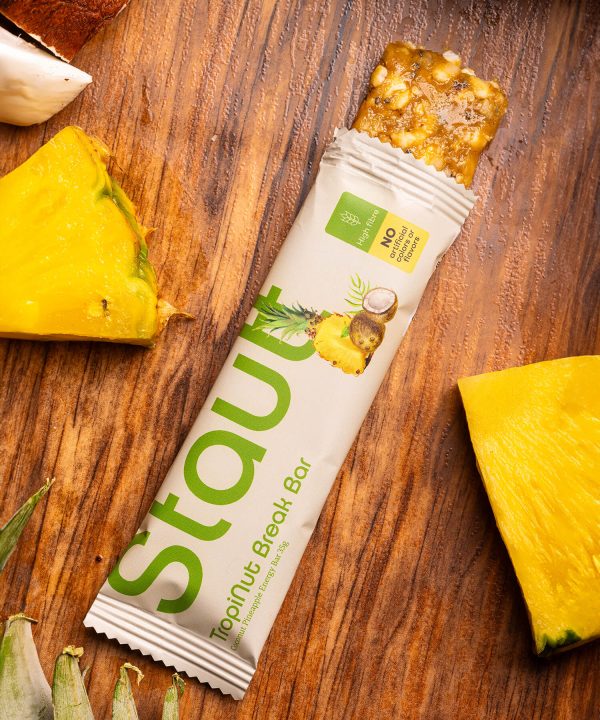 Barra nutricional de ananás e coco TropiNut Break Bar da Stautt, embalagem sobre ananás | TropiNut Break Bar pineapple and coconut nutrition bar by Stautt, pack on pineapple